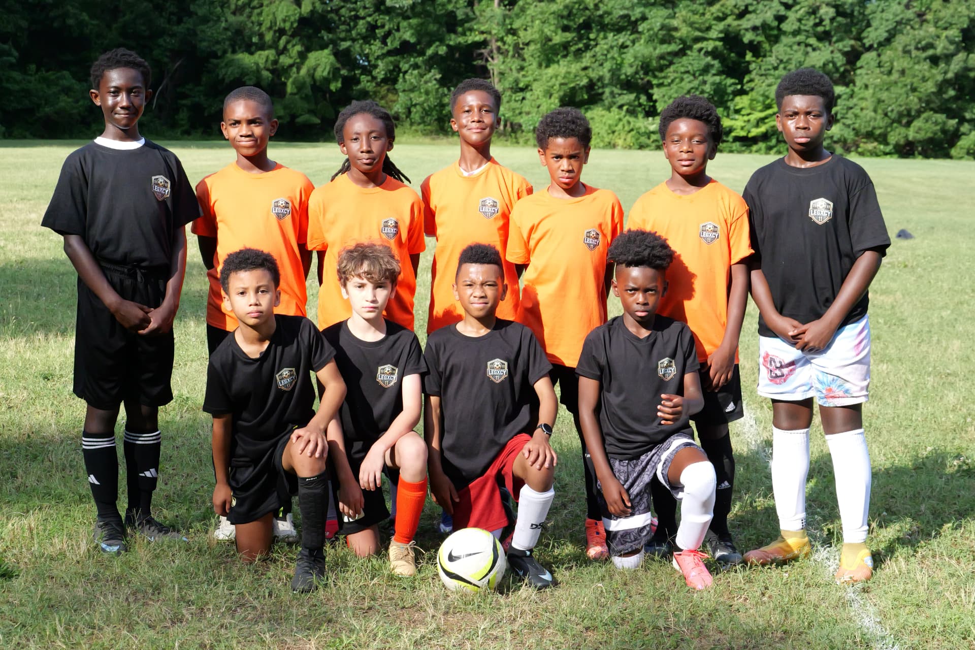 A Legacy squad lined up together on the field in academy shirts