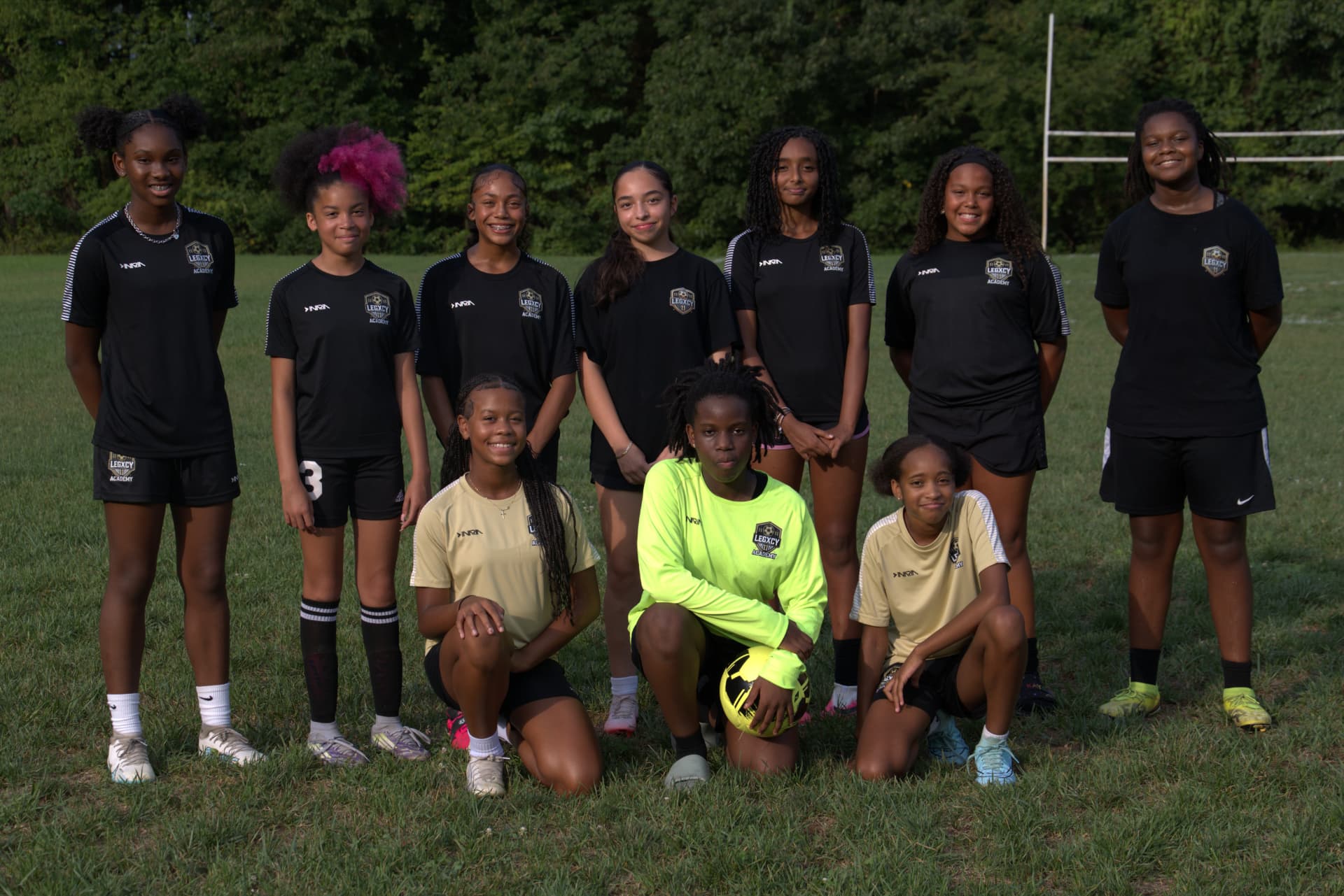The Legacy Lionesses squad smiling together on the field at Foxhill Park