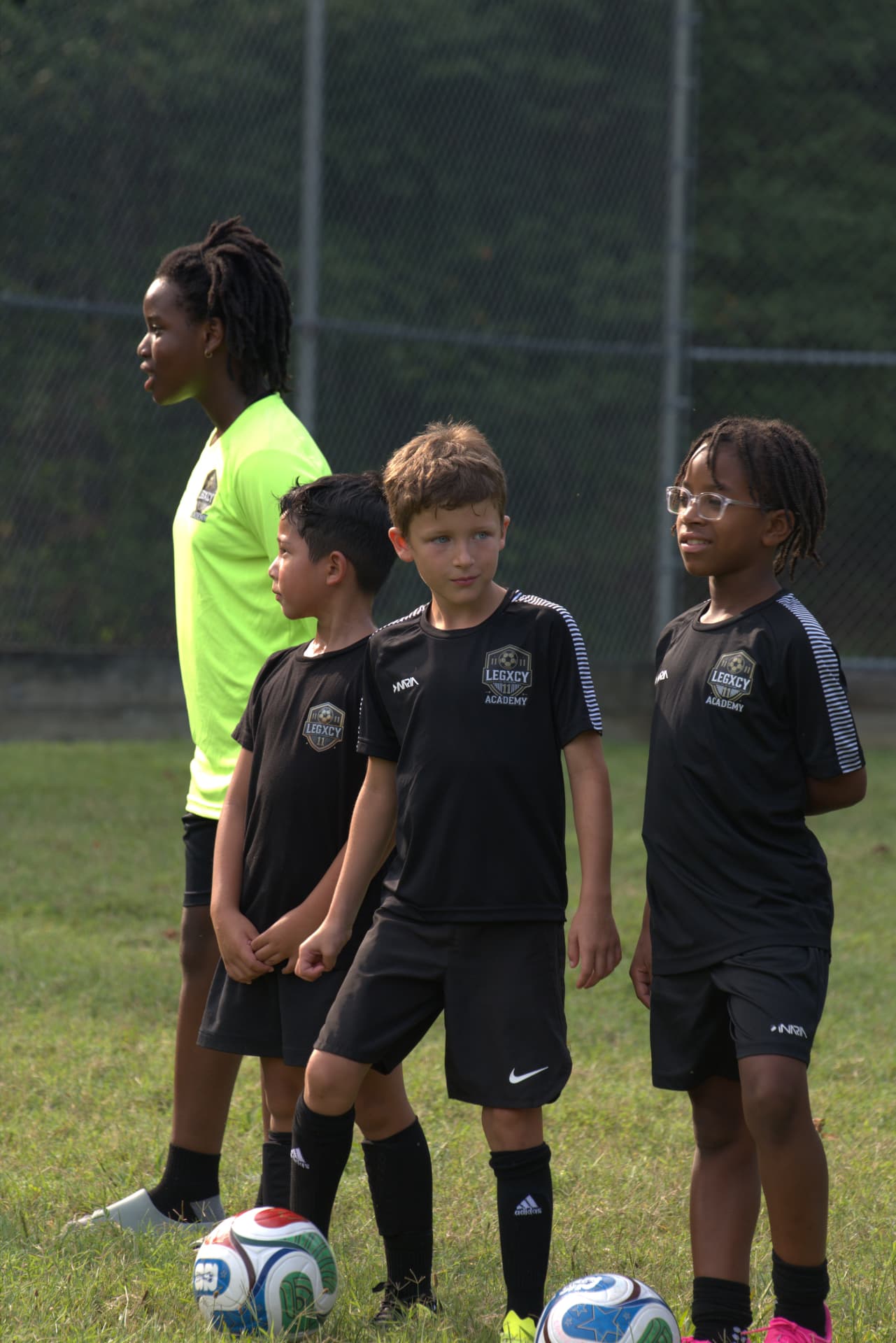 Young Legacy players lined up with footballs waiting to start a drill