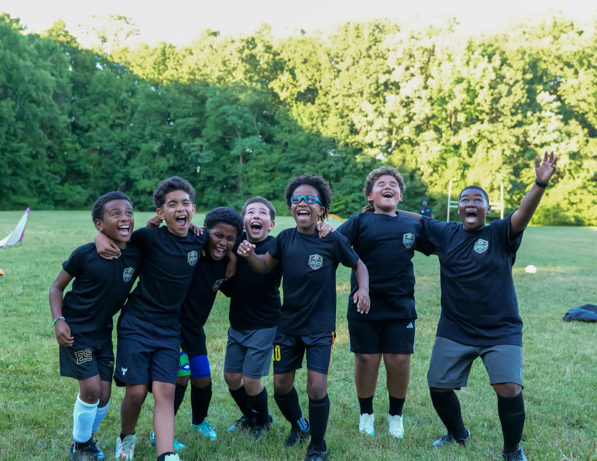 Legacy teammates laughing together with arms around each other after training