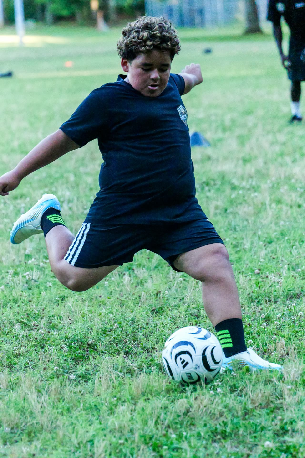 A Legacy player in a black academy shirt shooting during a finishing drill