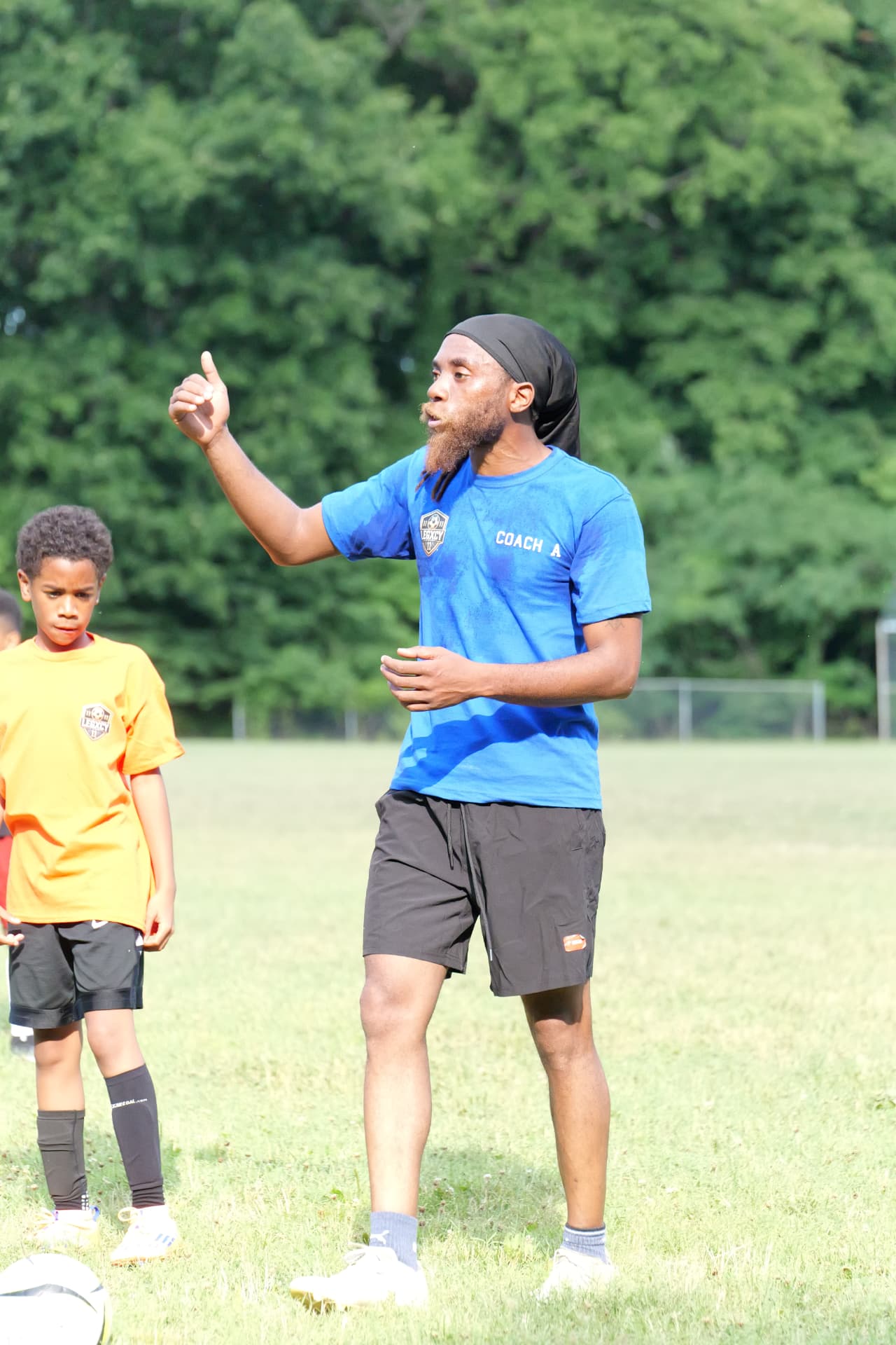 Coach A coaching a young Legacy player during a session at Foxhill Park