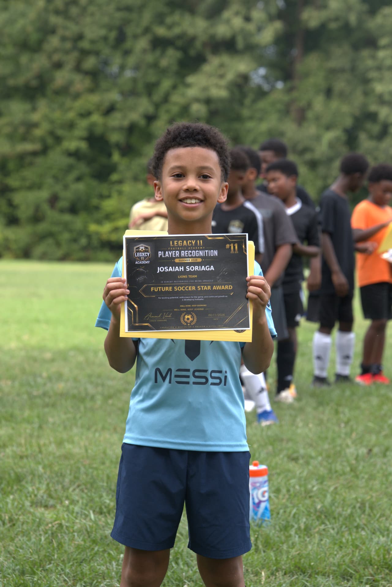 A young Legacy player holding up his Legacy 11 Player Recognition award certificate