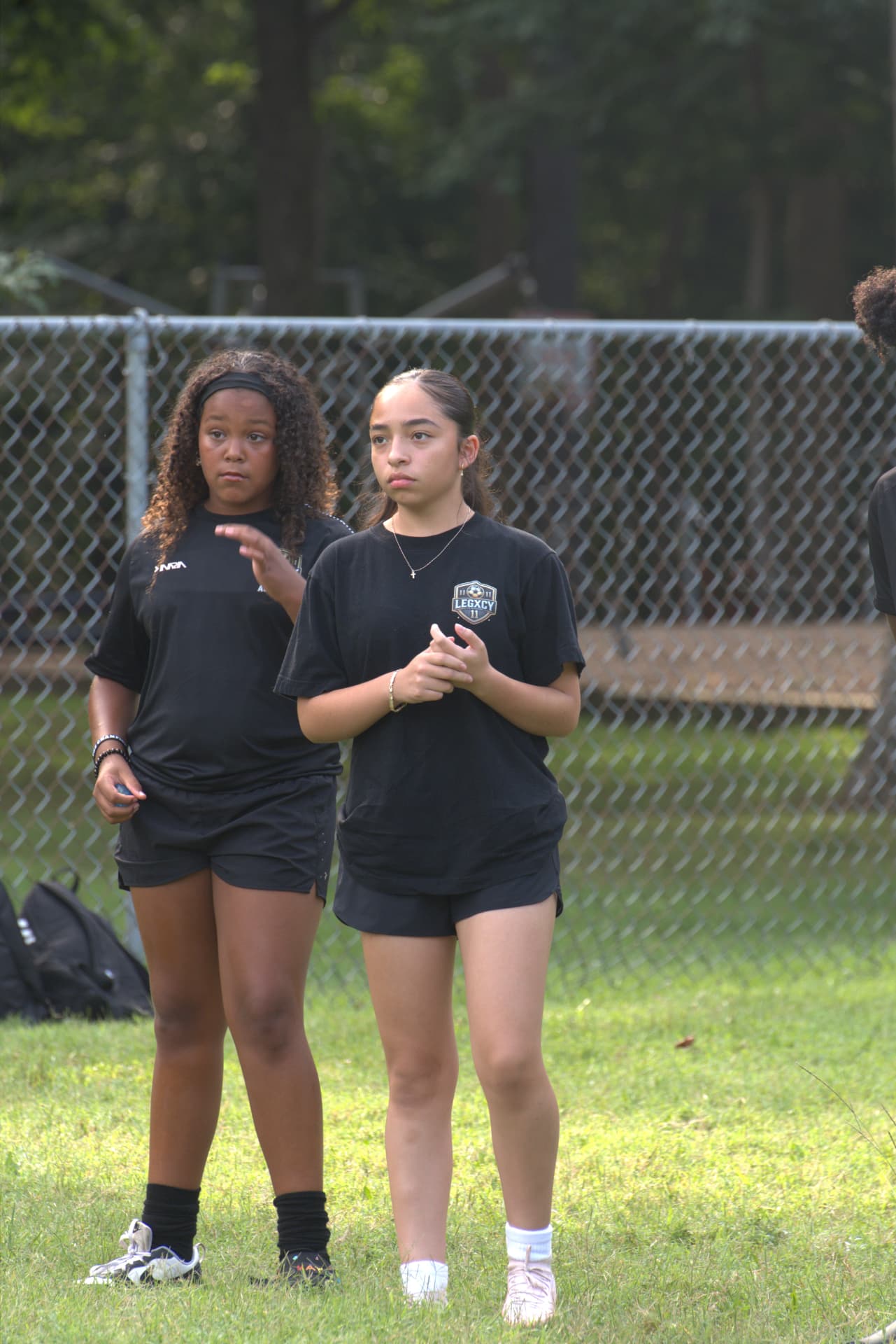 Two Legacy players listening to coaching instructions during training